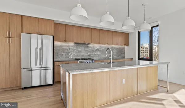 a kitchen with stainless steel appliances granite countertop a refrigerator a sink and a stove