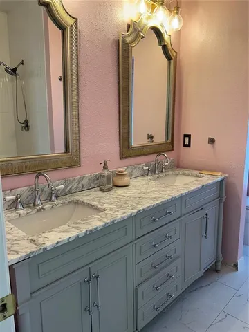 a bathroom with a granite countertop sink double and mirror