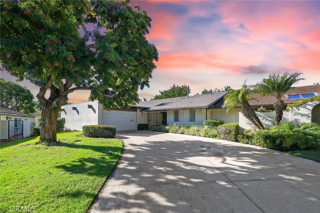 303 Esplanade Newport Beach, CA 92660 - Photo 1 of 20 a front view of a house with a garden and trees