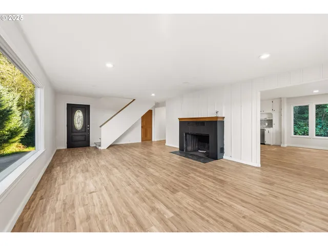 a view of an empty room with a window and fireplace