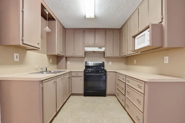 a kitchen with stainless steel appliances granite countertop a sink and cabinets