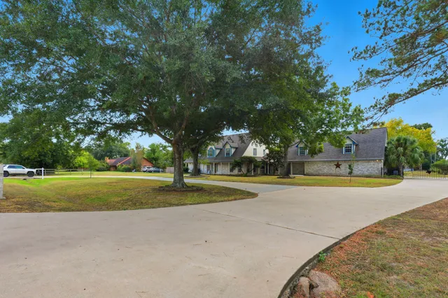 a view of a house with a big yard and large trees