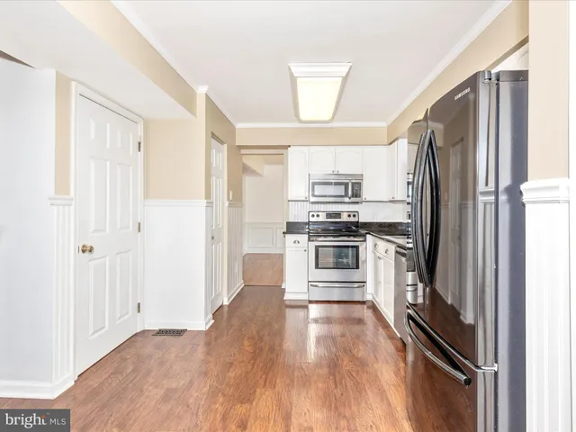 a kitchen with stainless steel appliances a refrigerator and a stove top oven