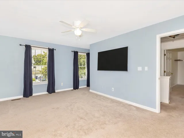 a view of an empty room with a chandelier fan