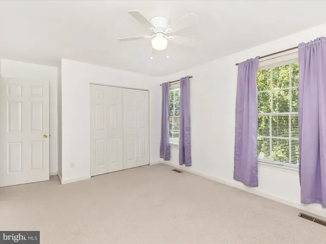 an empty room with a ceiling fan and a window