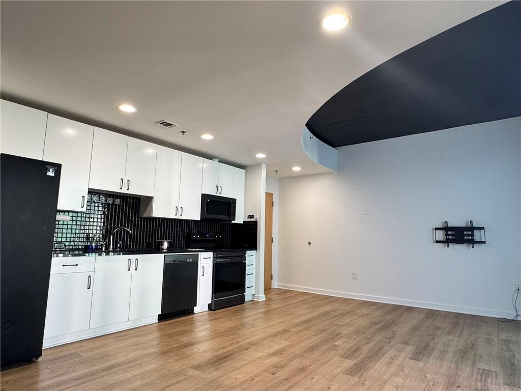 250 Pharr Road Northeast, Unit 601 Atlanta, GA 30305 - Photo 6 of 34 a kitchen with stainless steel appliances a refrigerator and a stove top oven