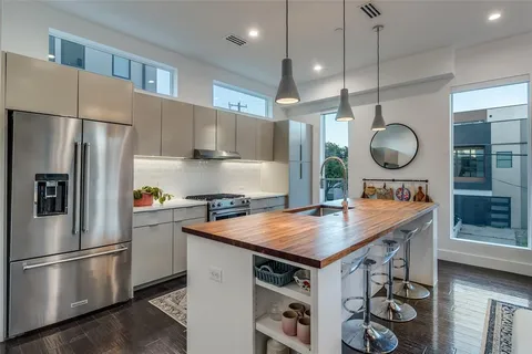 a kitchen with a refrigerator a sink and wooden floor