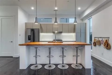 a kitchen with a sink a refrigerator and chairs