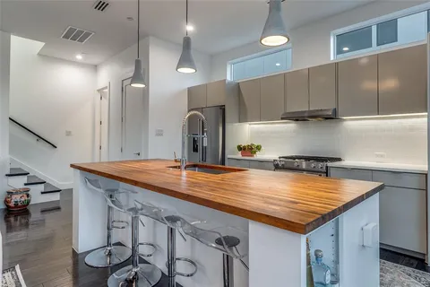 a kitchen with stainless steel appliances granite countertop a sink a stove and a wooden floors