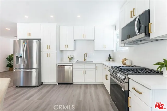 a kitchen with stainless steel appliances granite countertop a stove a refrigerator and a sink