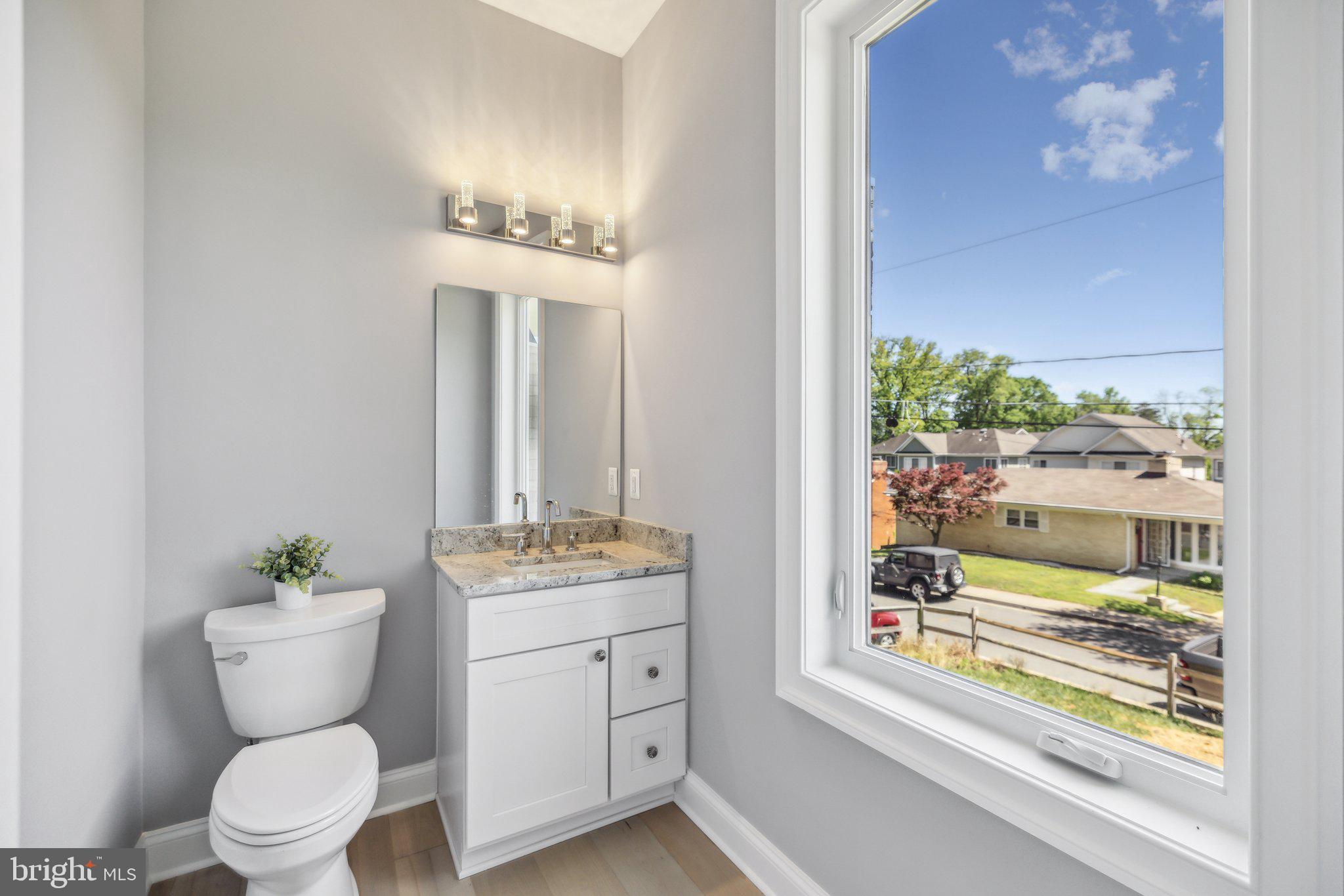 2811 21st Road South Arlington, VA 22206 - Photo 15 of 49 a bathroom with a toilet a sink a mirror and a window