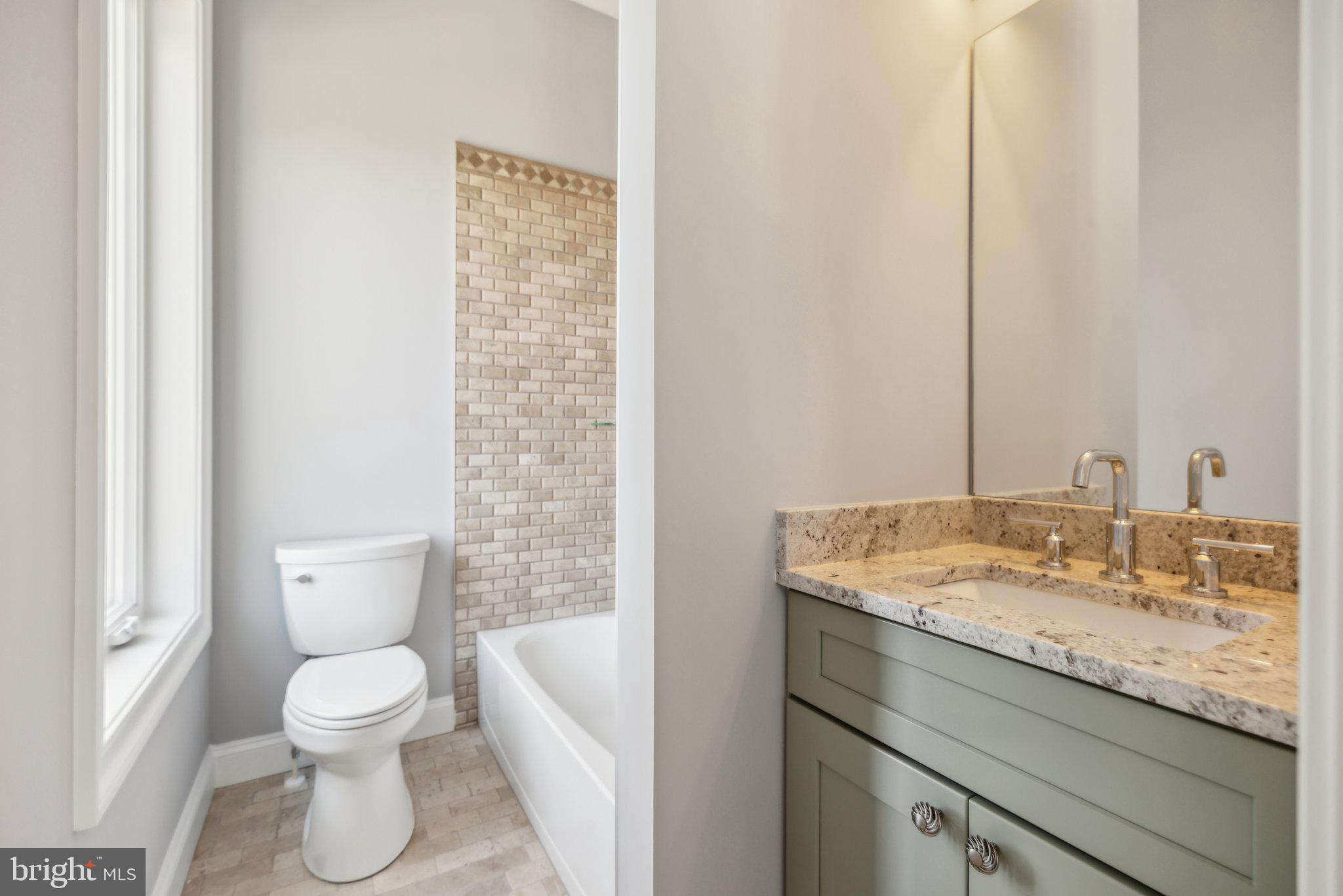 2811 21st Road South Arlington, VA 22206 - Photo 26 of 49 a bathroom with a granite countertop toilet a sink and a mirror