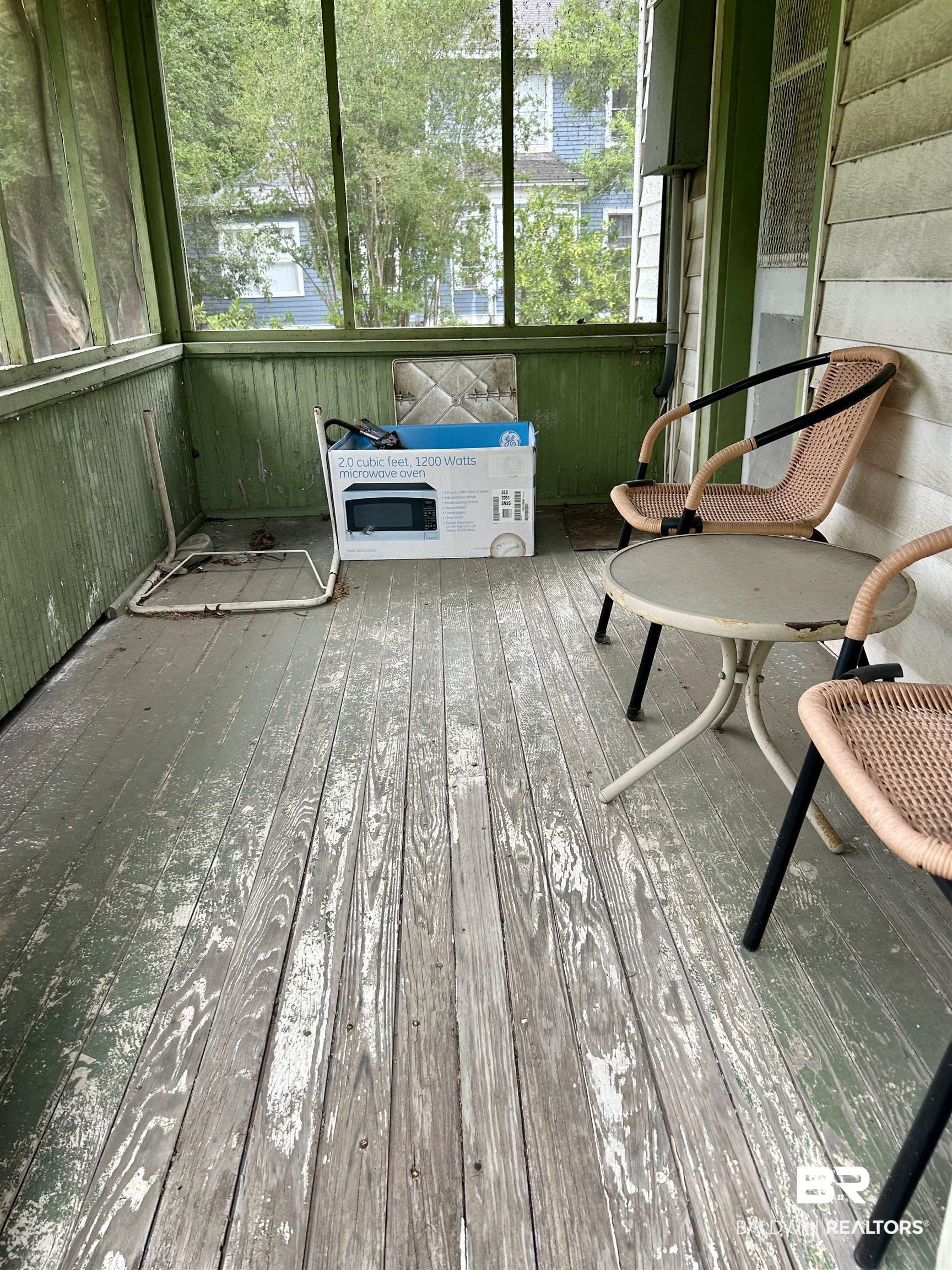 302 Stocking Street Mobile, AL 36604 - Photo 30 of 31 Enclosed porch featuring wood-panel walls, glass windows, and painted wood flooring