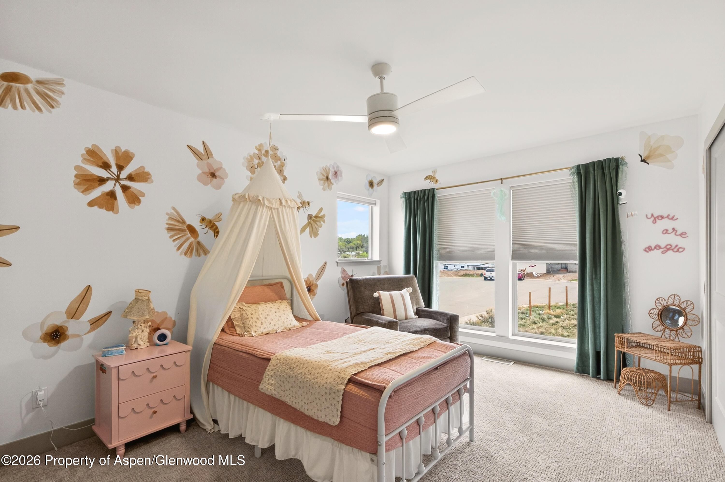 1395 Rifle Heights Drive Rifle, CO 81650 - Photo 27 of 35 a bedroom with a bed and a chandelier