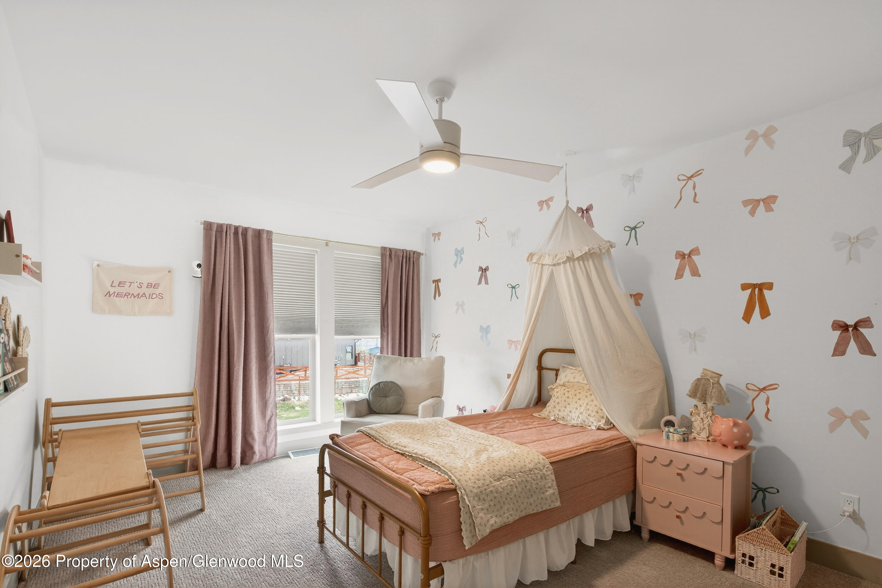 1395 Rifle Heights Drive Rifle, CO 81650 - Photo 28 of 35 a bedroom with a bed and a chandelier