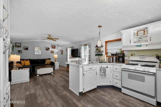 a kitchen with granite countertop a sink cabinets and stainless steel appliances