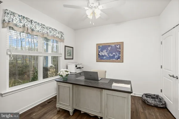 a living room with stainless steel appliances kitchen island granite countertop a sink a counter space and a view of kitchen