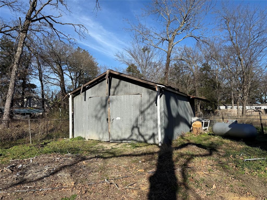 10300 Tanglewood Circle, Unit 1 Wills Point, TX 75169 - Photo 4 of 13 a street view with tall trees and a wooden fence
