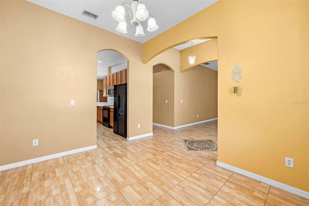 4211 Blakemore Place Spring Hill, FL 34609 - Photo 11 of 42 a view of a hallway with wooden floor and chandelier