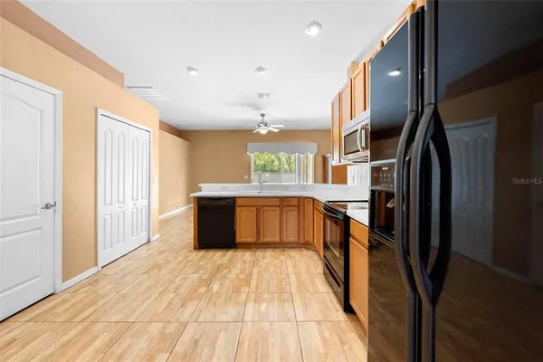 a large kitchen with stainless steel appliances kitchen island a large counter top and a refrigerator