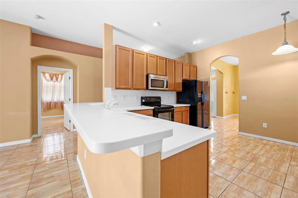 4211 Blakemore Place Spring Hill, FL 34609 - Photo 15 of 42 a large kitchen with a large counter top stainless steel appliances and cabinets