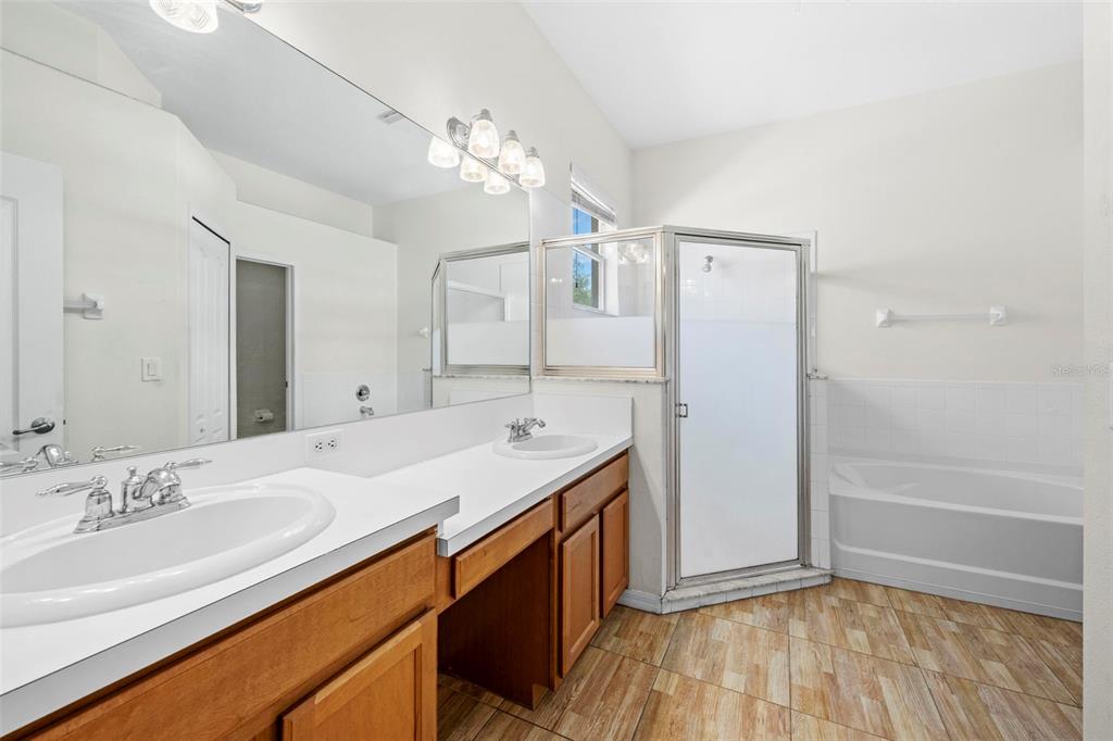 4211 Blakemore Place Spring Hill, FL 34609 - Photo 25 of 42 a bathroom with a sink double vanity granite tub and shower