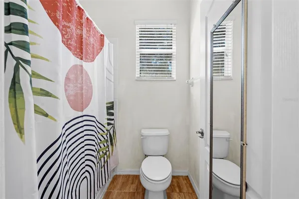 a bathroom with a toilet a sink and a mirror
