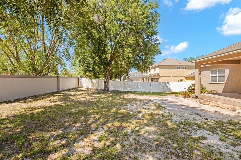 4211 Blakemore Place Spring Hill, FL 34609 - Photo 42 of 42 a view of a yard with a tree and wooden fence