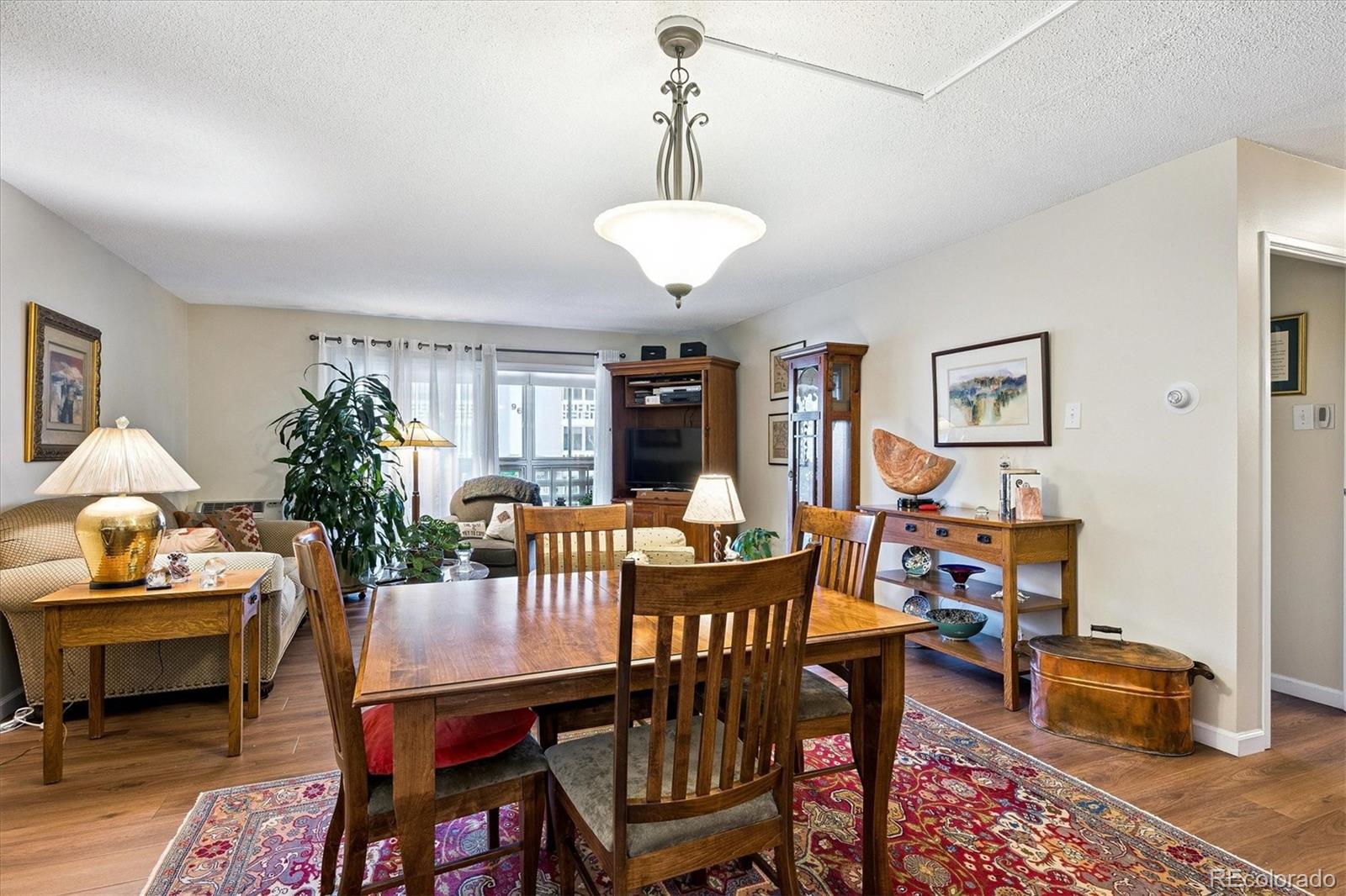 9625 Center Avenue, Unit 7B Denver, CO 80247 - Photo 4 of 49 a dining room with furniture a rug and a chandelier
