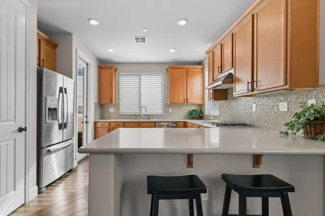 a kitchen with stainless steel appliances granite countertop a sink refrigerator and cabinets