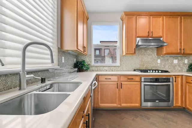 a kitchen with stainless steel appliances granite countertop a sink a stove and cabinets