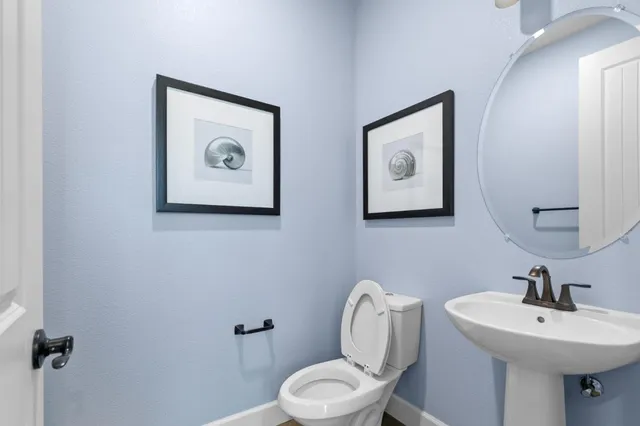a bathroom with a toilet a sink and mirror