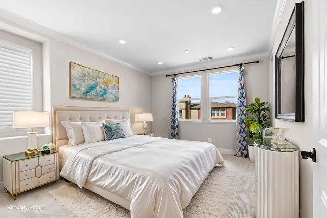 a spacious bedroom with a large bed and a potted plant