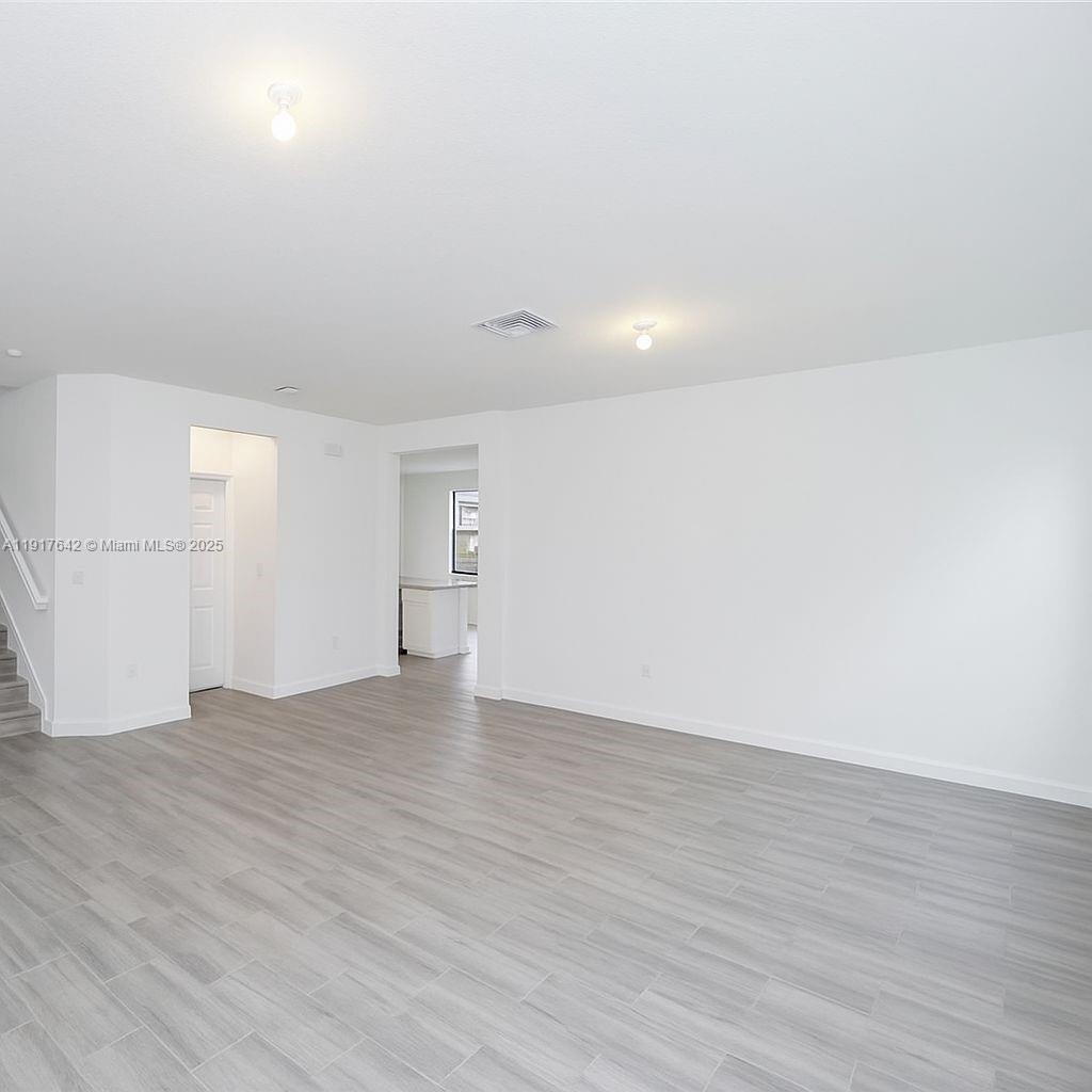 244 Northeast 210th Way, Unit 244 Miami, FL 33179 - Photo 12 of 32 a view of an empty room with wooden floor