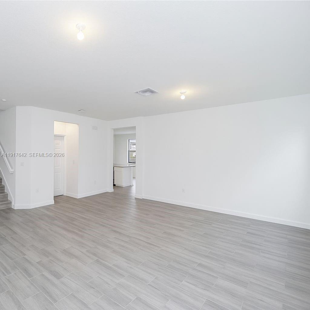 244 Northeast 210th Way, Unit 244 Miami, FL 33179 - Photo 12 of 32 a view of an empty room with wooden floor