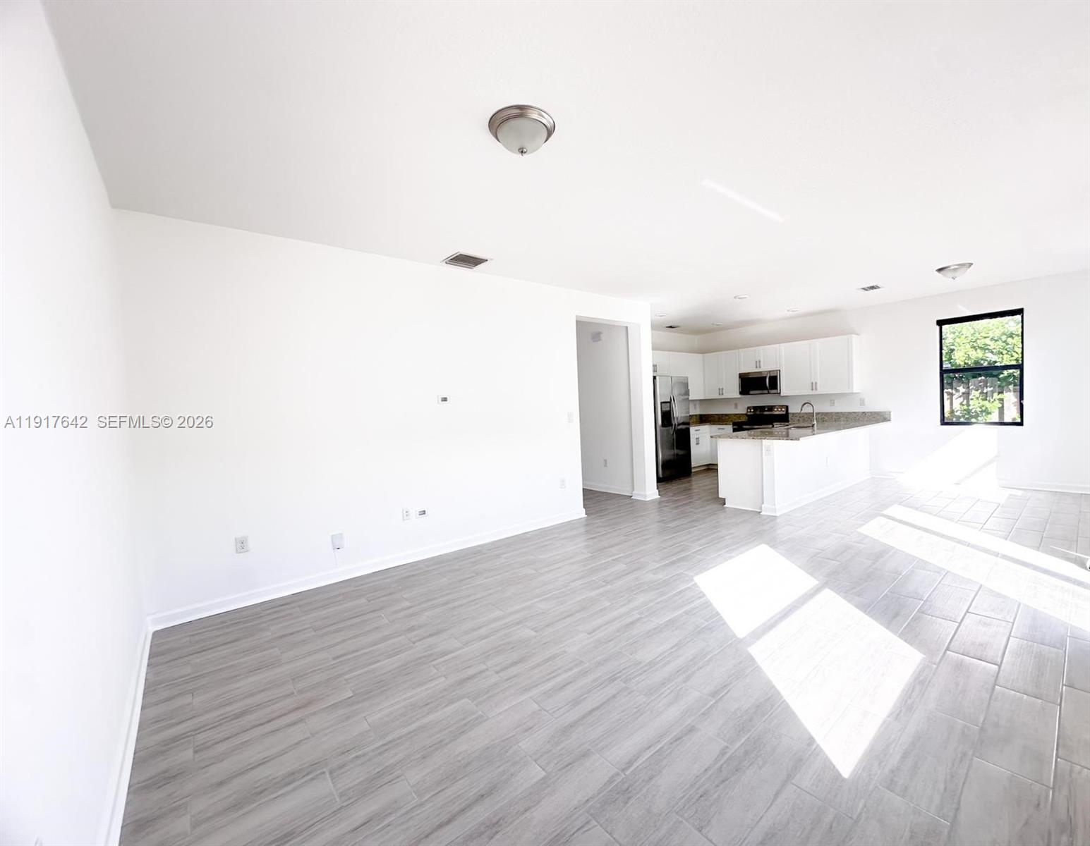 244 Northeast 210th Way, Unit 244 Miami, FL 33179 - Photo 16 of 32 a view of a kitchen with a sink and dishwasher with wooden floor
