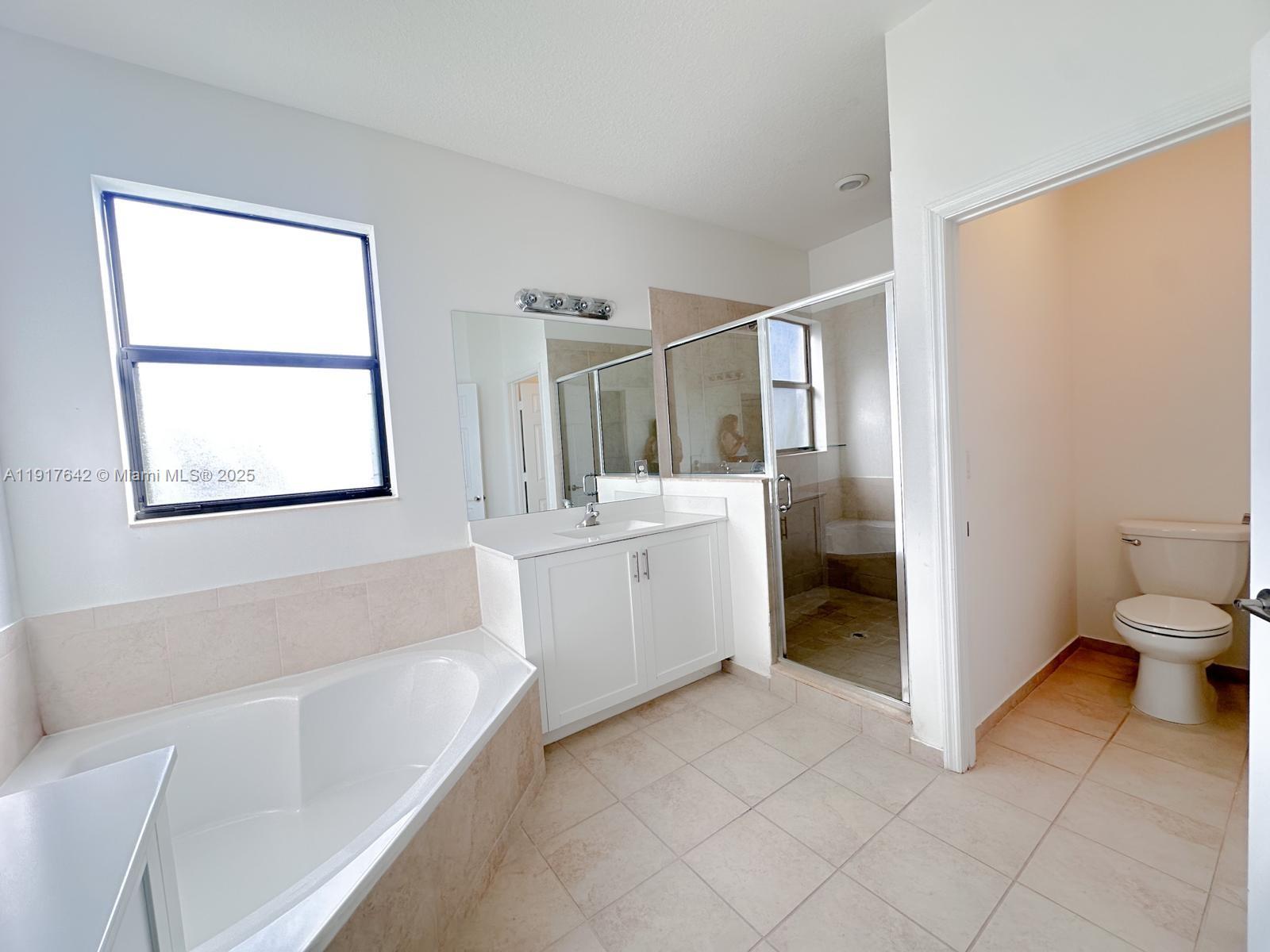 244 Northeast 210th Way, Unit 244 Miami, FL 33179 - Photo 17 of 32 a bathroom with a bathtub sink and toilet
