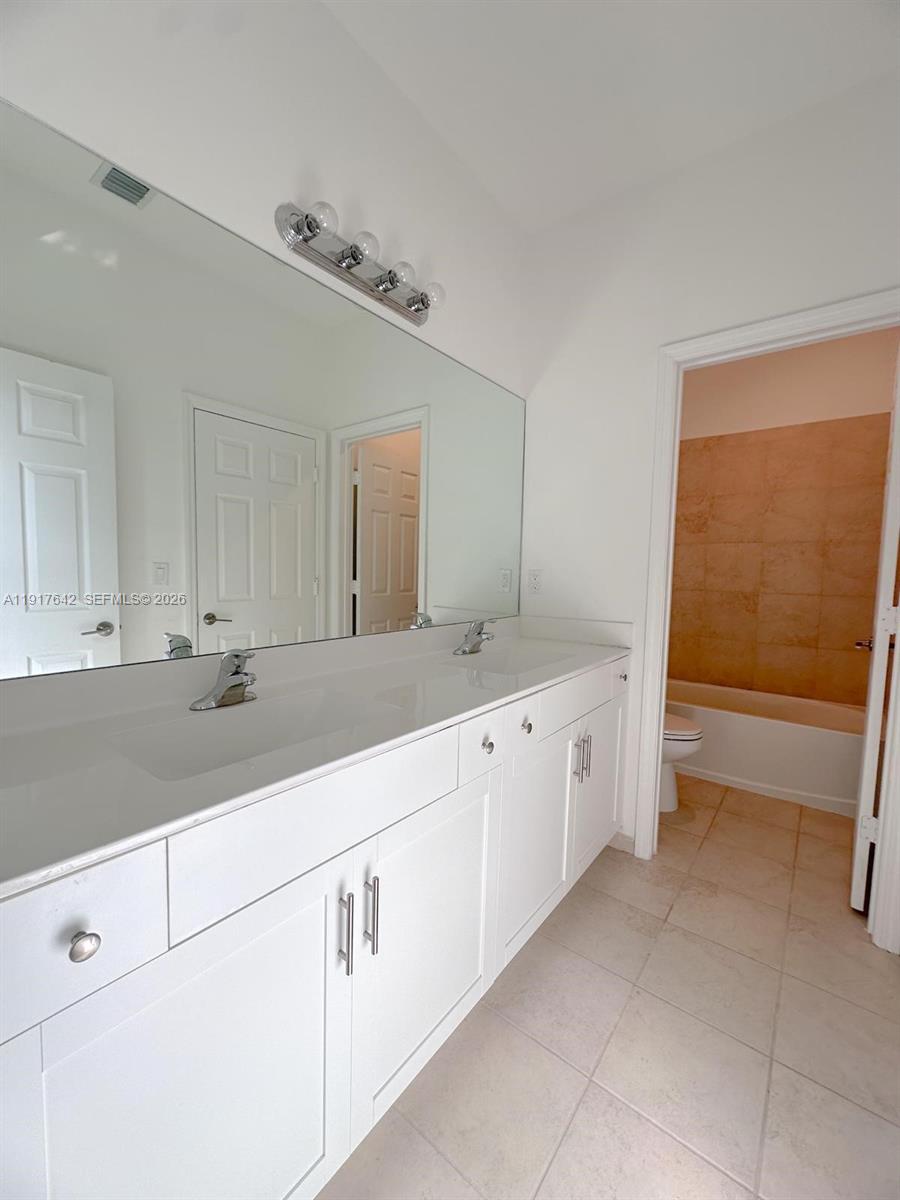 244 Northeast 210th Way, Unit 244 Miami, FL 33179 - Photo 19 of 32 a spacious bathroom with a sink and a mirror