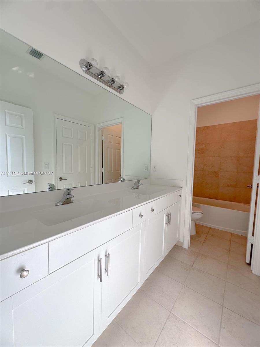 244 Northeast 210th Way, Unit 244 Miami, FL 33179 - Photo 19 of 32 a spacious bathroom with a sink and a mirror