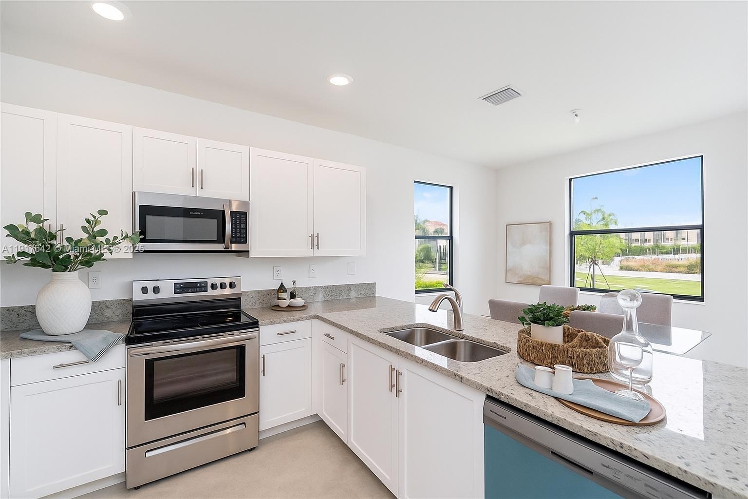 244 Northeast 210th Way, Unit 244 Miami, FL 33179 - Photo 2 of 32 a kitchen with a sink stove and microwave