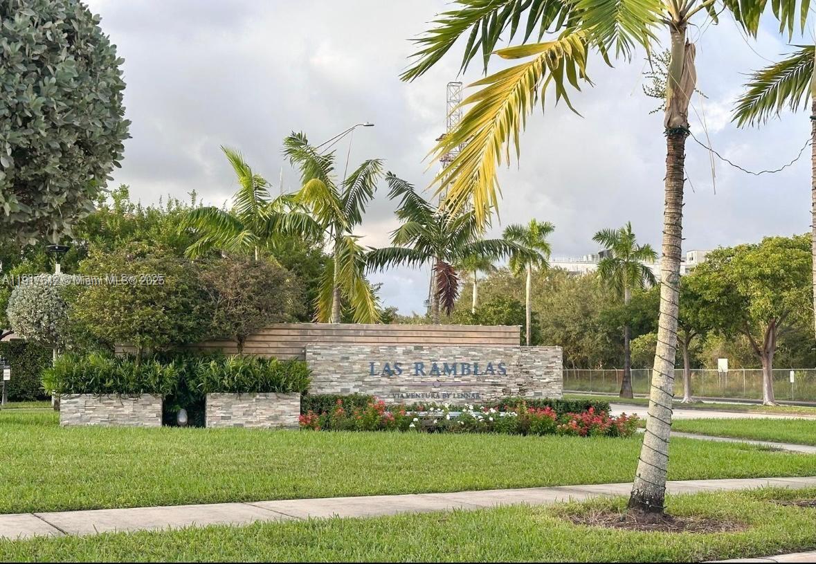 244 Northeast 210th Way, Unit 244 Miami, FL 33179 - Photo 32 of 32 a view of a white house with a big yard and a palm trees