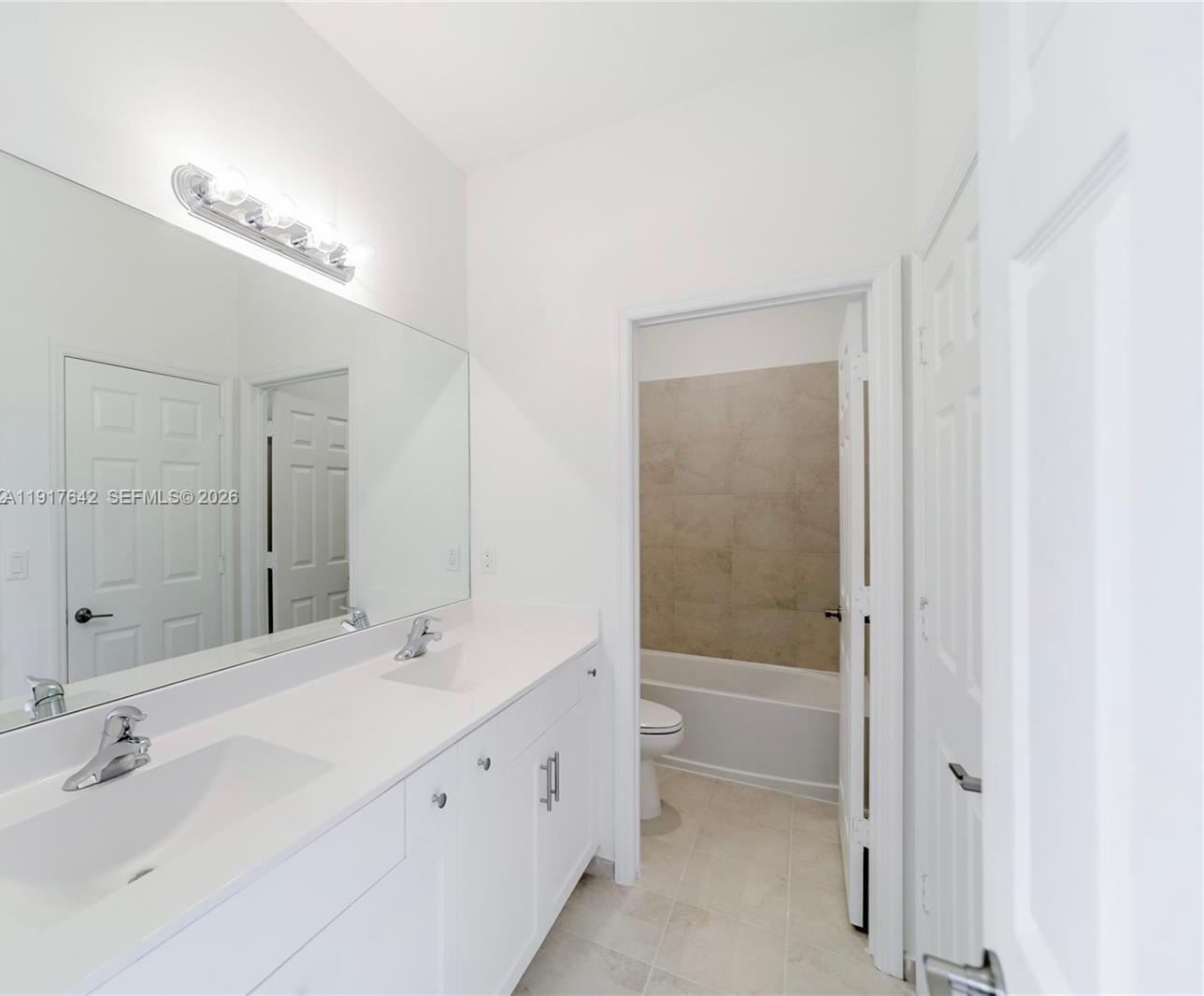 244 Northeast 210th Way, Unit 244 Miami, FL 33179 - Photo 6 of 32 a bathroom with a bathtub shower sink vanity and mirror