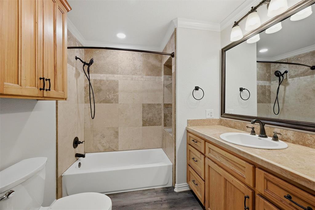 909 Thatcher Street Denison, TX 75020 - Photo 13 of 24 a bathroom with a tub sink toilet and a mirror