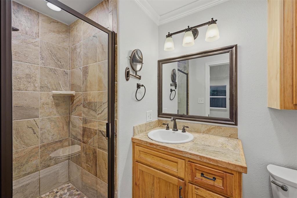 909 Thatcher Street Denison, TX 75020 - Photo 16 of 24 a bathroom with a sink vanity granite and a mirror