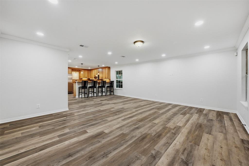 909 Thatcher Street Denison, TX 75020 - Photo 3 of 24 an empty room with wooden floor and breakfast area