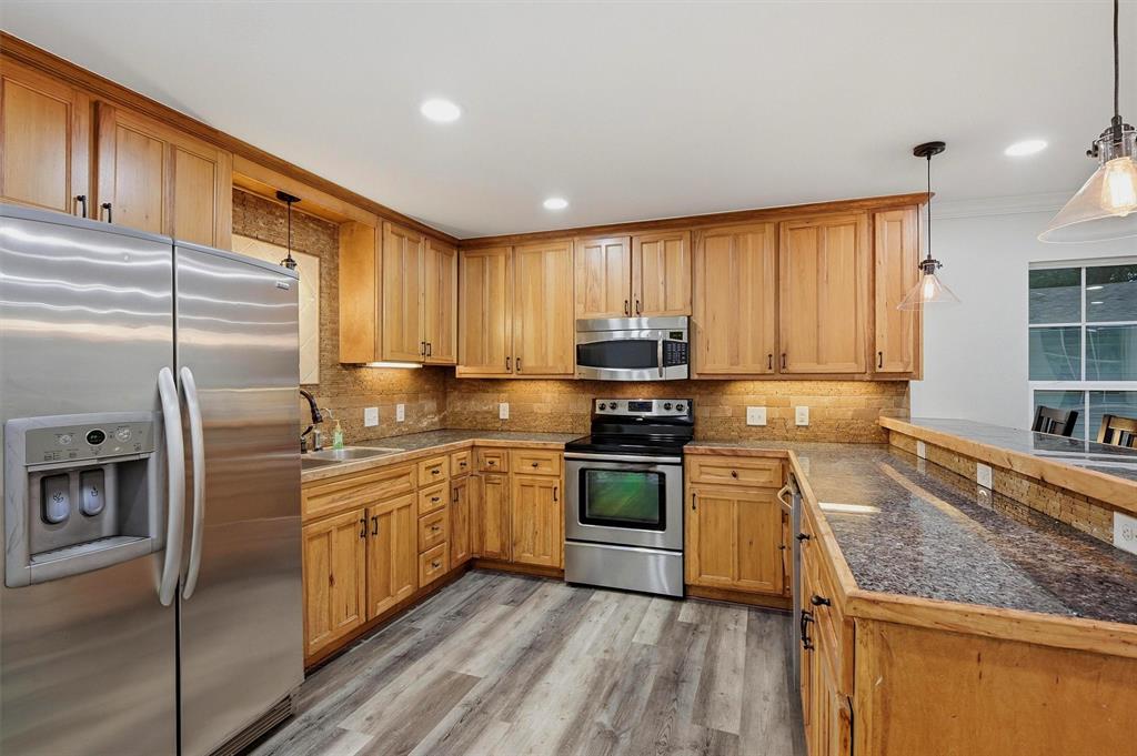 909 Thatcher Street Denison, TX 75020 - Photo 7 of 24 a kitchen with stainless steel appliances granite countertop a stove a sink and a refrigerator