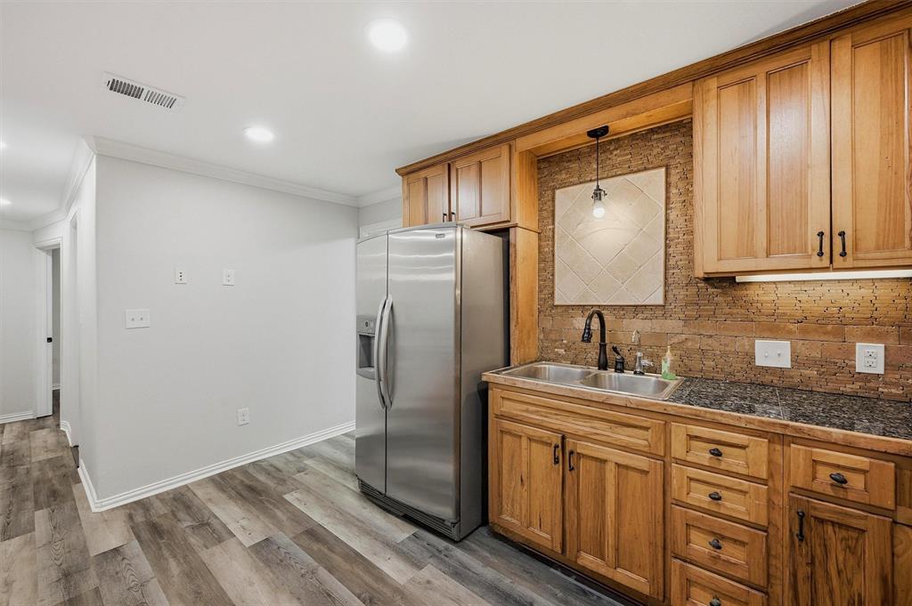 909 Thatcher Street Denison, TX 75020 - Photo 8 of 24 a bathroom with a granite countertop sink a mirror and shower