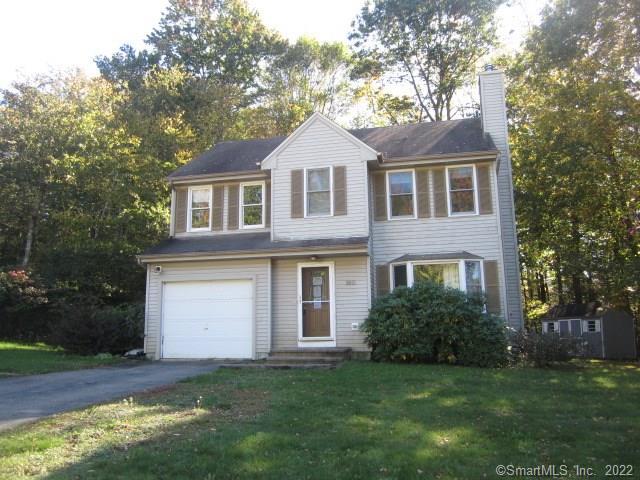 a front view of a house with a garden and yard