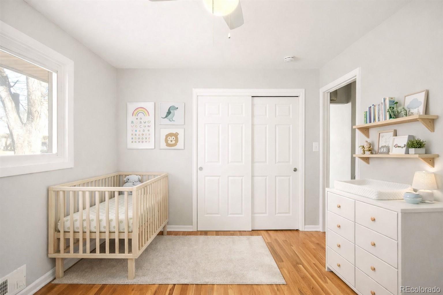 2438 South Perry Street Denver, CO 80219 - Photo 12 of 24 a view of a bedroom with wooden floor and windows