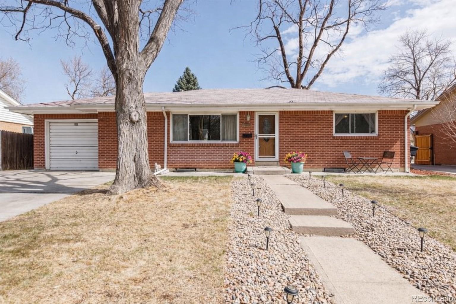 2438 South Perry Street Denver, CO 80219 - Photo 16 of 23 a front view of a house with a yard and glass windows